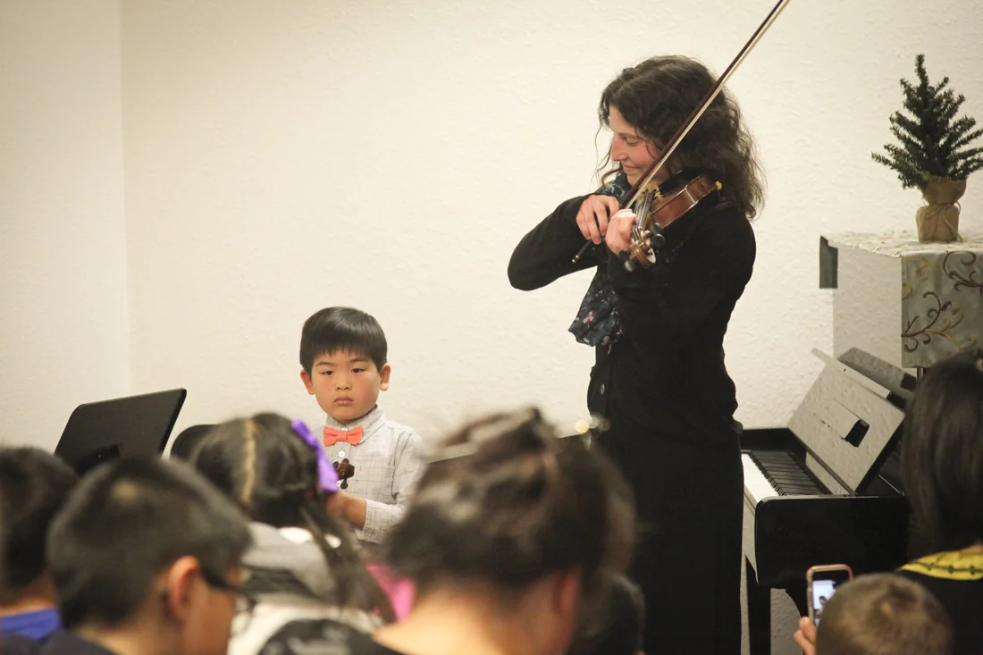 Violin teacher and student playing a duet