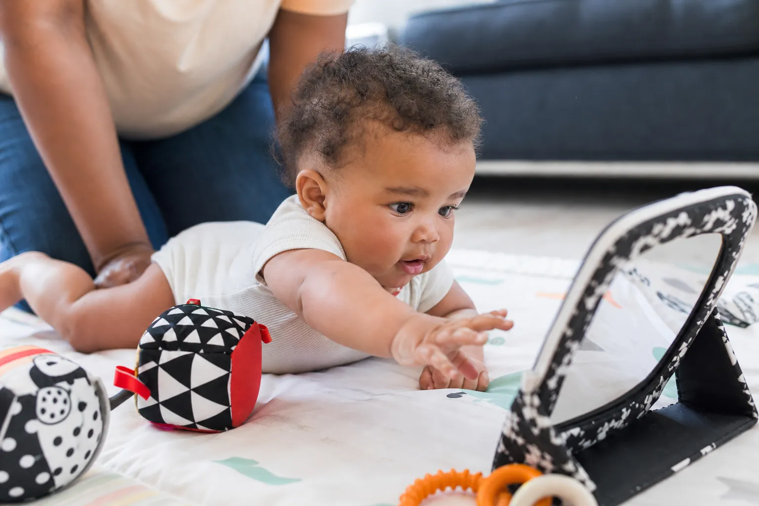 infant reaching toward a mirror during tummy time